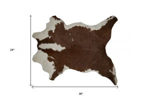 HomeRoots 2' X 3' Hand-Tufted Brown and White Cowhide Print Area Rug - Rustic Charm for Any Space! 293165
