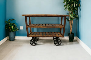 Homeroots 48" Brown And Black Solid Wood Distressed Wheel Console Table With Storage   488851