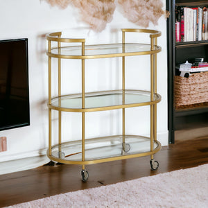 Homeroots Brass Steel And Glass Oval Rolling Bar Cart   530454