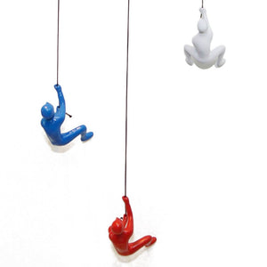 HomeRoots Set of Three Climbing Man Resin Sculptures - Whimsical 3D Wall Art in Blue, Red & White Finish 544459