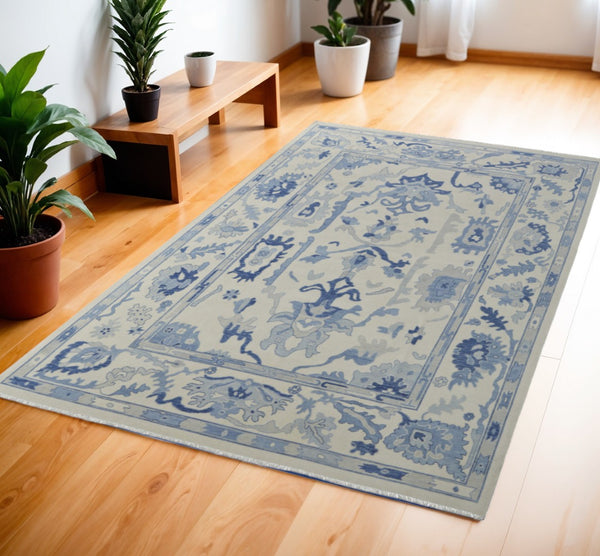 HomeRoots 4' Ivory and Blue Floral Hand-Knotted Wool Area Rug with Elegant Fringe for Timeless Home Style 4' X 6' 566298