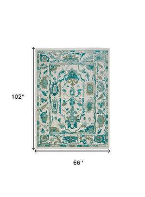 HomeRoots 4' Ivory and Blue Floral Hand-Knotted Wool Area Rug with Elegant Fringe for Timeless Home Style 6' X 9' 566305