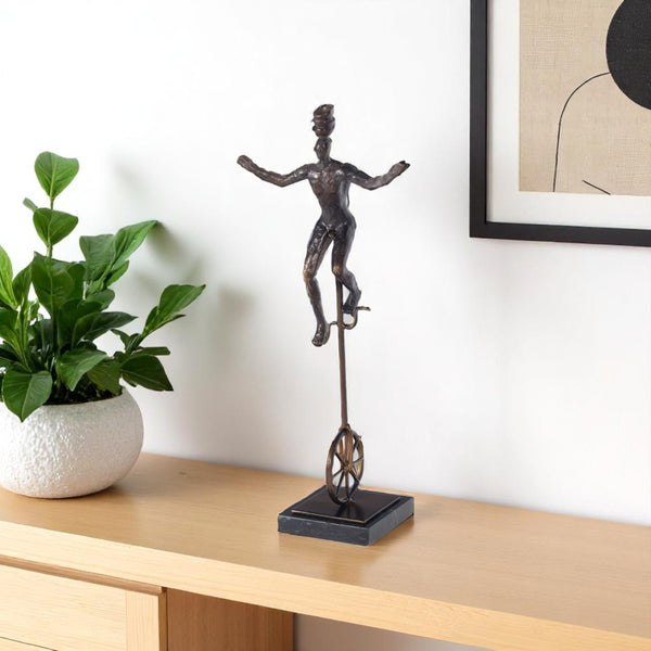 HomeRoots 16" Bronze Resin Unicycle Man Sculpture - Whimsical Art for Stylish Tabletop Décor & Gift Ideas 574103