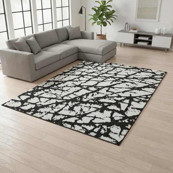 HomeRoots 9' X 12' Black And Ivory Abstract Rug - Washable, UV Protected, Durable Design for High-Traffic Areas 676811